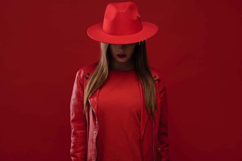 Kobieta w czerwonym kapeluszu zasłaniającym oczy - anonimowość na OnlyFans
